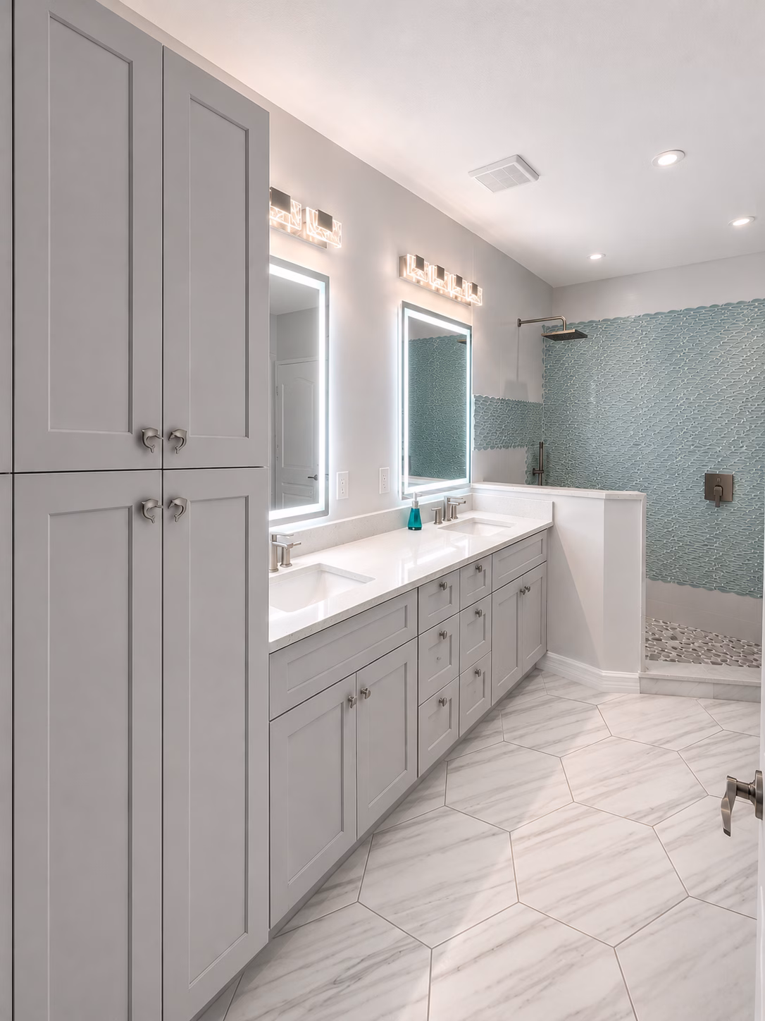 Bathroom with aqua glass tile shower, white double vanity and linen cabinet, remodeled by BFM Builders