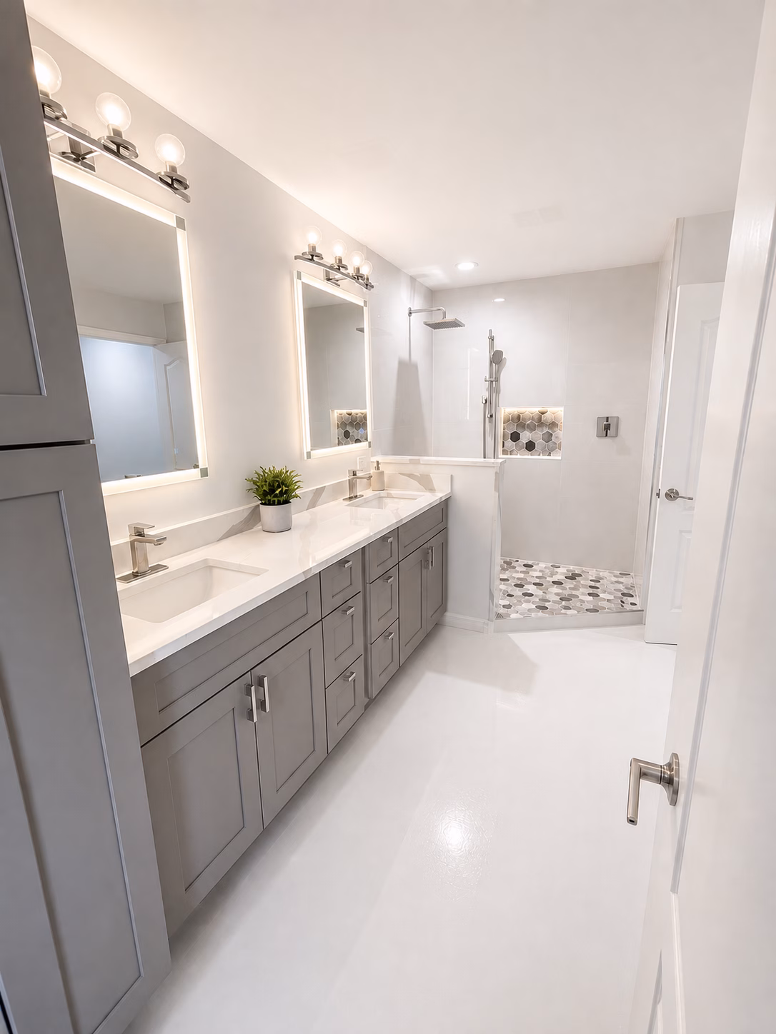 Master bathroom with gray double vanity and walk-in shower with hexagon tile floor, remodeled by BFM Builders