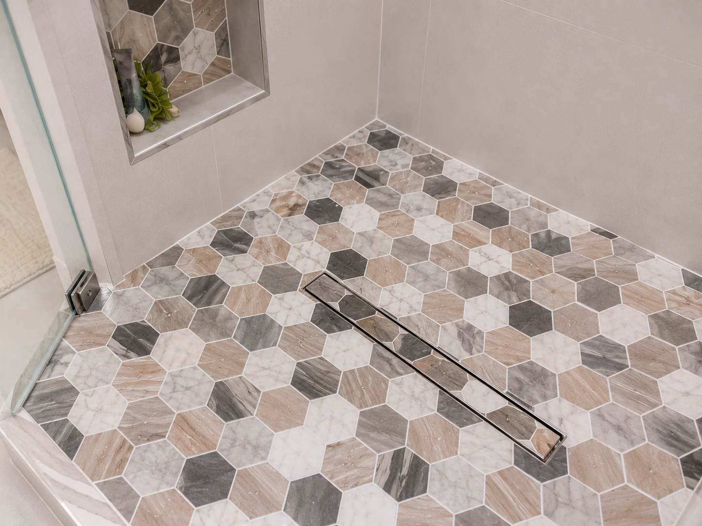 Hexagon tile shower floor with a linear drain and a tiled niche, remodeled by BFM Builders