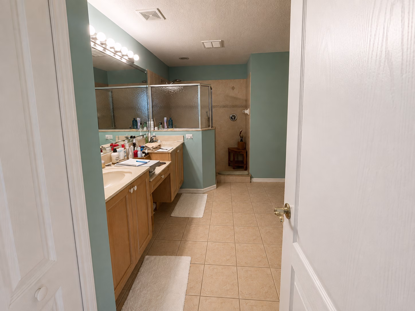 Master bathroom before the BFM Builders remodel, with a wood vanity and framed corner shower