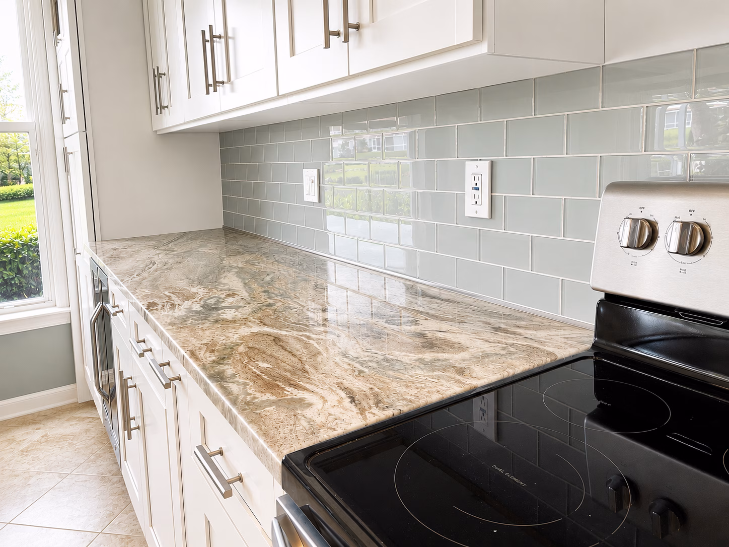 Granite countertop and glass subway tile backsplash in an open-concept kitchen remodeled by BFM Builders
