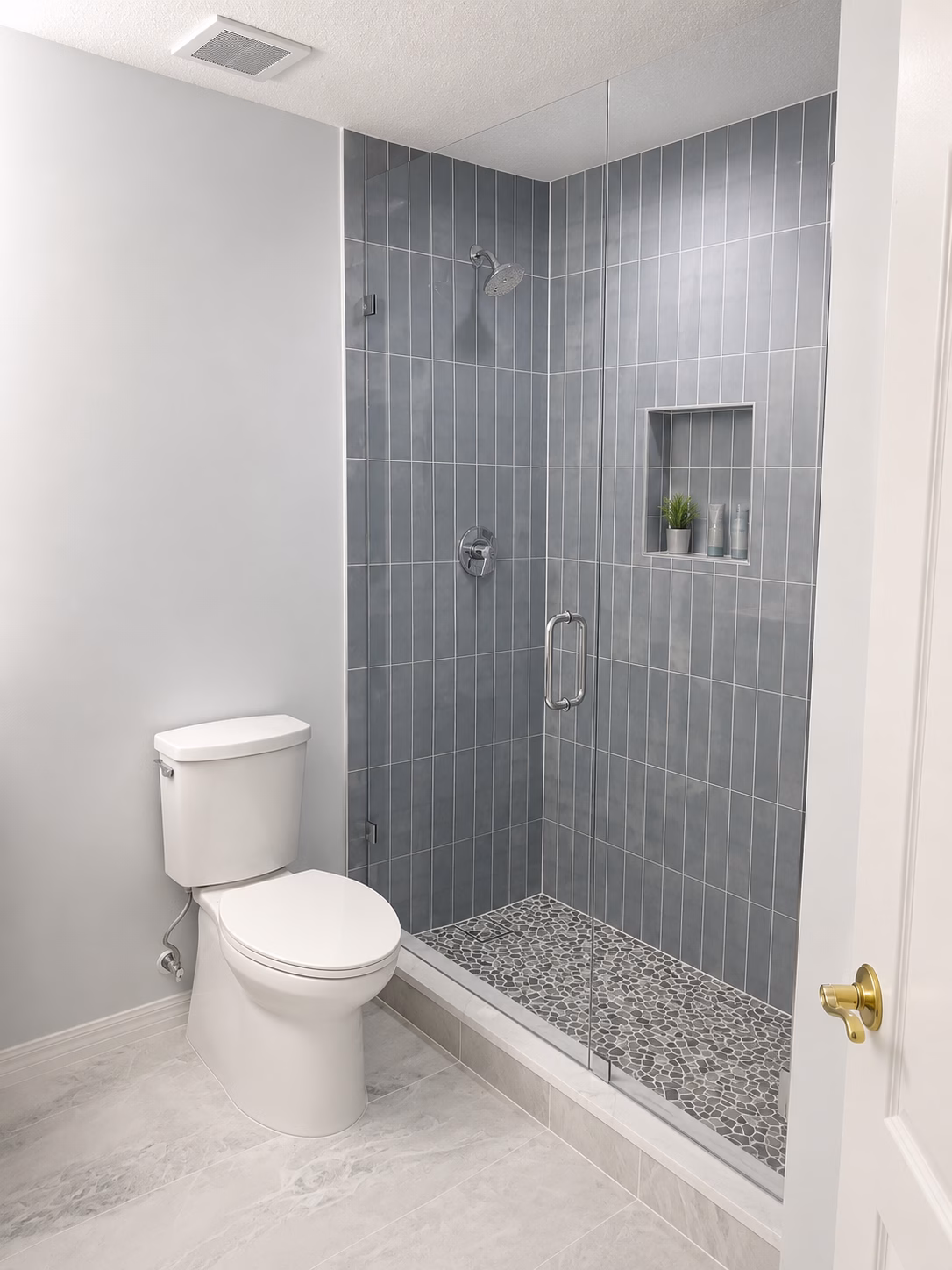 Guest bathroom with slate-blue vertical tile shower, niche and navy vanity, remodeled by BFM Builders